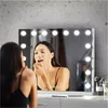 A woman applying makeup in front of a lighted vanity mirror. Produktbild-Vorschau
