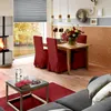 A dining and living area with a fireplace, dining table, and sofa. Produktbild-Vorschau