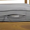 A close-up view of a gray cushion with a partially open zipper, revealing white filling, resting on a wooden surface. Anteprima dell’immagine prodotto