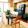 A dining room with a table set for a meal and a large cabinet in the background. Anteprima dell’immagine prodotto