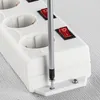 A close-up shot of a white power strip with red switches, with a screwdriver being used to tighten a screw on the base. Produktbild-Vorschau