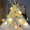 A close-up shot of a teepee decorated with pom-pom string lights. Produktbild-Vorschau