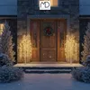 A snowy front porch decorated for Christmas with illuminated willow trees and a wreath on the door. Podgląd zdjęcia produktu