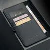 A close-up view of a black leather wallet with cards and cash inside. Produktbild-Vorschau