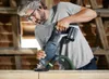 A man is using a reciprocating saw in a wooden structure. Voir les images du produit