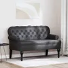 A black Chesterfield bench is shown in a room with a painting on the wall and a curtain in the background. Náhled obrázku produktu