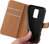 A hand holding a black phone case that is part of a brown flip cover case. Produktbild-Vorschau