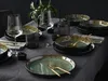 A table setting with plates, bowls, glasses, and cutlery, suggesting a dining experience. Produktbild-Vorschau