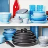 A collection of kitchenware, including pots, pans, bowls, and glasses, neatly arranged on white shelves. Anteprima dell’immagine prodotto