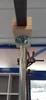 A close-up view of a telescopic pole supporting a metal beam, with wooden blocks and a metal plate connecting them. Produktbild-Vorschau