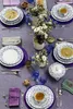 A beautifully set dining table with floral patterned plates, soup bowls, and teacups, adorned with floral arrangements. Produktbild-Vorschau