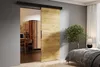 A sliding door is shown partially open, revealing a home office on one side and a bedroom on the other. The door has a wood grain finish. Produktbild-Vorschau
