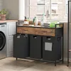 A laundry cart with three bags and two drawers is shown next to a washing machine in a laundry room. Produktbild-Vorschau
