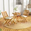 A wooden bistro set with two chairs and a table on a patio with a hanging chair in the background. Náhled obrázku produktu