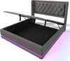 A grey upholstered bed frame with its storage lift mechanism open, revealing the storage space underneath. Purple LED lights are visible along the base of the bed frame. Anteprima dell’immagine prodotto