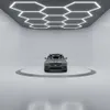 A car is displayed on a rotating platform in a showroom with hexagonal lighting on the ceiling. Podgląd zdjęcia produktu