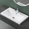A white rectangular sink with a chrome faucet is installed on a dark gray countertop against a dark green wall. Produktbild-Vorschau