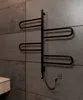 A black electric towel warmer is mounted on a gray tiled wall. Náhľad obrázku produktu
