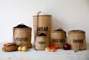 A collection of burlap storage bags for kitchen produce, including bread, potatoes, garlic, vegetables, and onions, arranged on a wooden surface. Náhled obrázku produktu