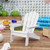 A white Adirondack chair for children is placed on a wooden deck in a backyard setting, with a sandbox, inflatable pool, and toys visible in the background. Produktbild-Vorschau