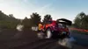 A rally car drifting on a dirt track with smoke billowing from its tires. Produktbild-Vorschau