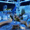 A decorated outdoor patio at night with blue string lights. Náhled obrázku produktu