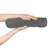 Hands holding a gray cylindrical pillow. Produktbild-Vorschau
