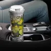 A portable blender filled with ingredients sits in a car's cup holder. Podgląd zdjęcia produktu