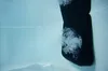 A black object, possibly a part of a whirlpool or spa, submerged in light blue water with bubbles. Náhled obrázku produktu