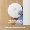 A white robot vacuum cleaner is shown on a wooden floor, cleaning near a white wall. A close-up inset shows the cleaning mechanism. Produktbild-Vorschau