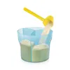 A yellow scoop is pouring powder into a blue, multi-compartment container. Produktbild-Vorschau