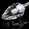 A close-up studio shot of a decorative LED light bulb with a faceted crystal-like glass enclosure and a metallic screw base, set against a black reflective surface. Produktbild-Vorschau
