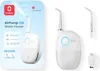 The image shows the packaging of a water flosser on the left and the product itself with accessories on the right. Náhled obrázku produktu