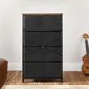 A SONGMICS Kommode with fabric drawers and a wooden top, placed on a wooden floor next to a brown leather ottoman and a ukulele. Náhled obrázku produktu