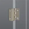 A close-up view of a metal hinge attached to two gray surfaces, likely a cabinet or door. Podgląd zdjęcia produktu
