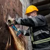 A construction worker wearing safety gear uses a Bosch angle grinder to cut into a metal surface, creating sparks. Náhľad obrázku produktu