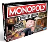 The image shows the box of the Monopoly Cheaters Edition board game, with a cartoonish depiction of Mr. Monopoly peeking from behind a stack of money and pointing to his lips, suggesting secrecy. The background features elements of a bank and a jail cell. Náhled obrázku produktu