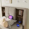 A close-up view of a bed headboard with built-in shelves, a tablet, and smartphones charging. Anteprima dell’immagine prodotto
