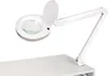 A white magnifying lamp with an adjustable arm is clamped to a white surface. Produktbild-Vorschau