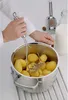 A person is mashing potatoes in a pot with a potato masher. A grater and a bottle of milk are visible in the background. Anteprima dell’immagine prodotto