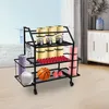 A multi-tiered storage rack filled with various fitness equipment, including yoga mats, kettlebells, foam rollers, a basketball, and boxing gloves, placed in a room with a window view and furniture in the background. Podgląd zdjęcia produktu
