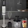 A hand mixer and its accessories are displayed on a wooden surface in a kitchen setting. Podgląd zdjęcia produktu