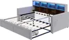 A light gray sofa bed is shown in an open state, revealing its mattress support and storage drawers. The headboard features built-in shelves illuminated with blue LED lights. Náhled obrázku produktu