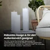 Three white LED candles on a table next to a potted plant and a chair. Produktbild-Vorschau