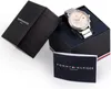 A Tommy Hilfiger watch is displayed in its open packaging, alongside its instruction booklet. Produktbild-Vorschau