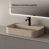 A modern bathroom sink with a black faucet, filled with water, placed on a ribbed cabinet. Voir les images du produit