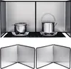 A kitchen stove with pots and a kettle, protected by splash guards. Produktbild-Vorschau