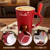 A red ceramic mug designed for chocolate fondue, with a candle holder underneath and a fork for dipping. The image includes close-up insets highlighting product features and usage. Produktbild-Vorschau