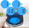 A digital kitchen scale with multiple measurement unit displays shown in blue digital readouts. A finger is pressing a button on the scale. Produktbild-Vorschau