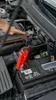 A person is using a jump starter to start a car battery. Náhled obrázku produktu